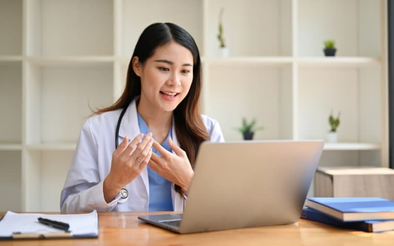 Woman consulting with a doctor from her couch via laptop